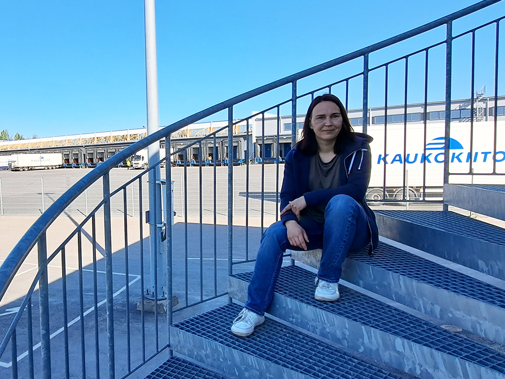 Heidi Suominen is sitting on the steps of Kaukokiito in Tampere in the photo.