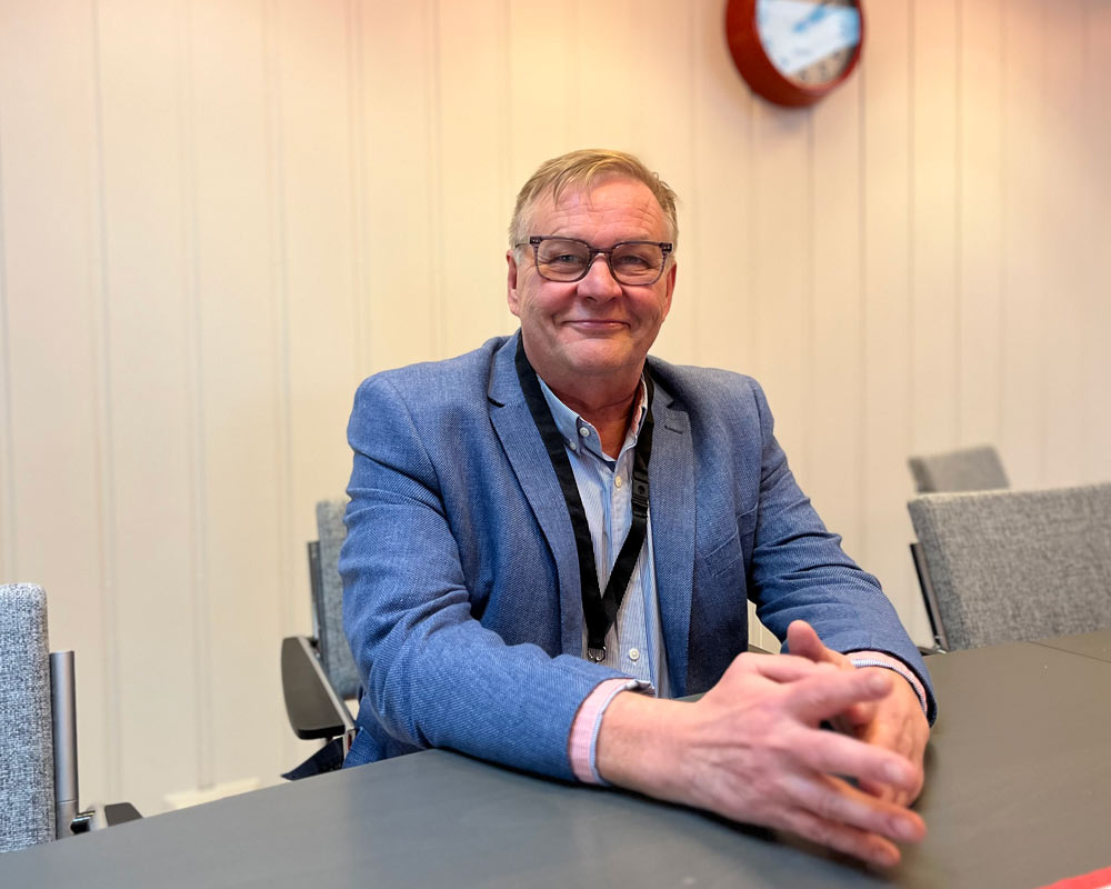 Aluejohtaja Mika Taalikka istuu pöydän äärellä